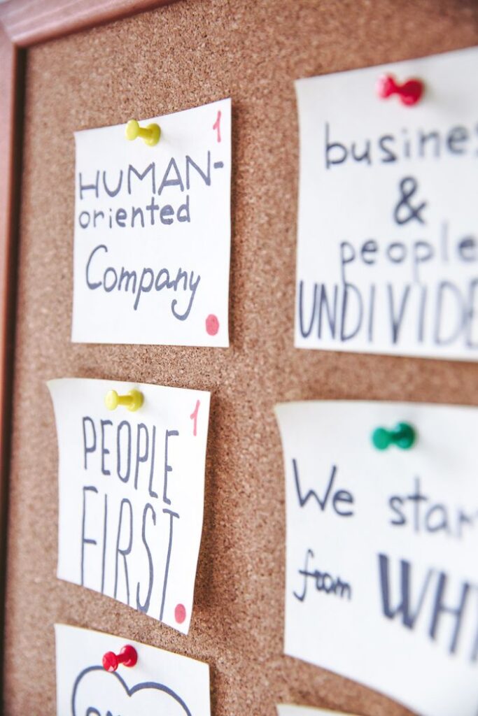 Pinned sticky notes on a cork board with motivational messages for business inspiration.